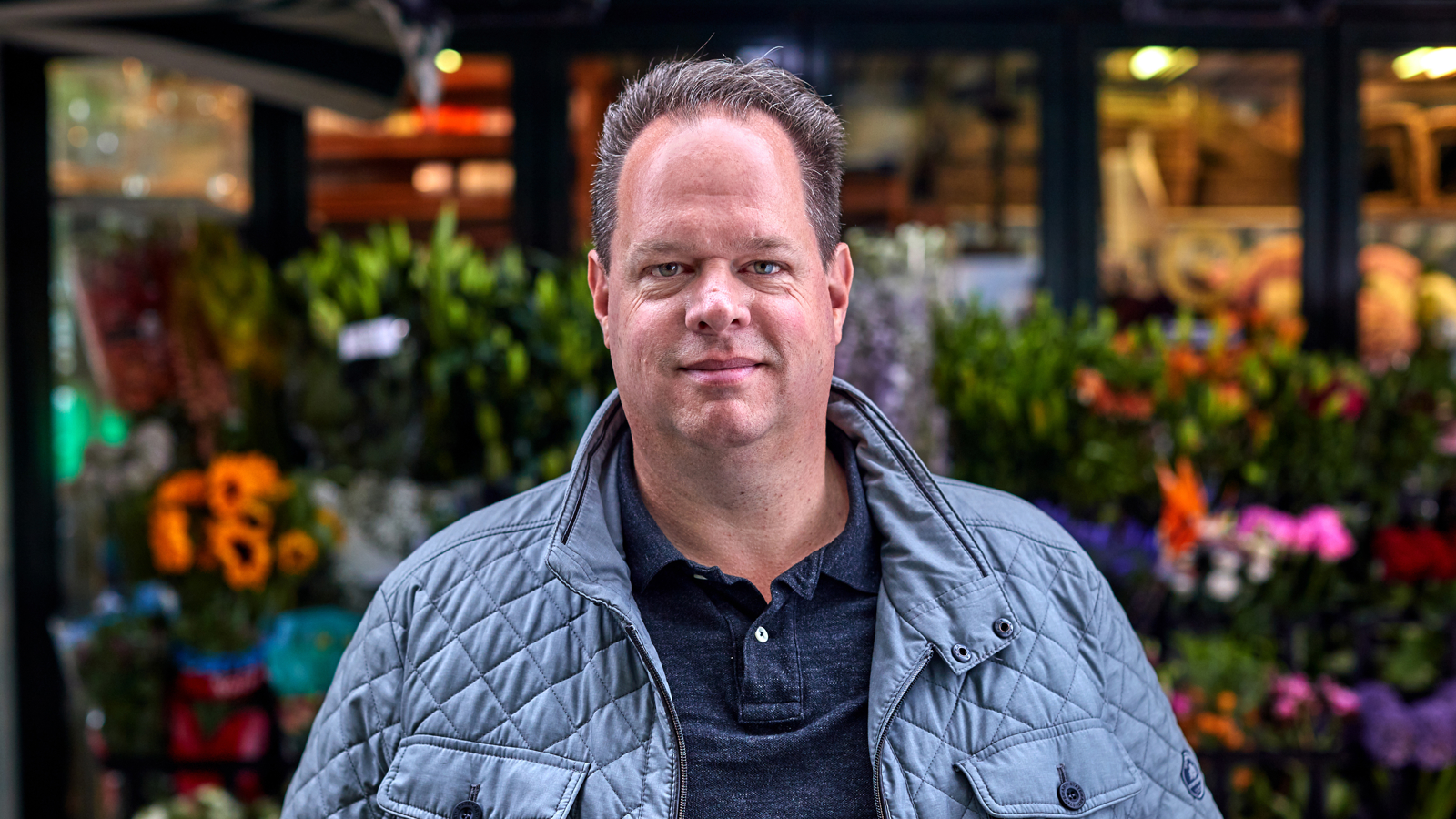 man voor bloemenstal